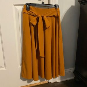 Orange skirt that falls below the knees. 98% polyester and 2% spandex.
